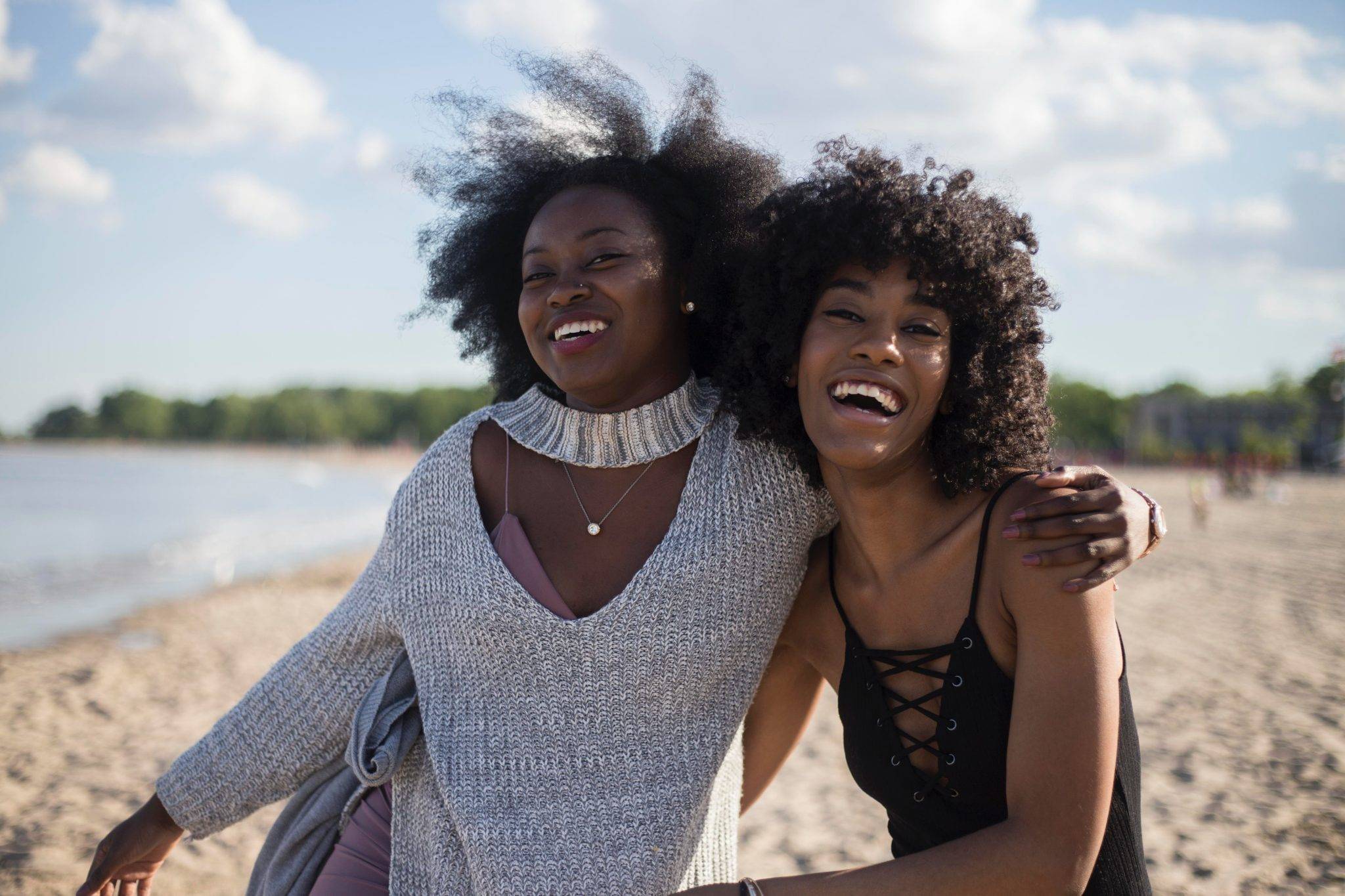 Two women smiling with arms around each other